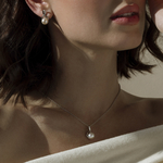 Set aus Anhänger und Ohrringen mit weißer Süßwasserperle im Infinity-Design – Modellbild