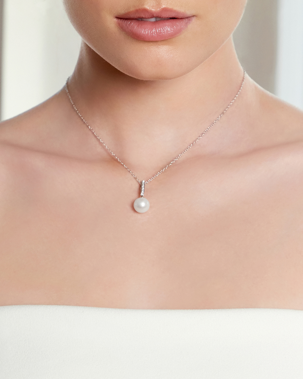 Das Model trägt einen Diamant-Anhänger mit 9–10 mm großen Perlen in AAAA-Qualität