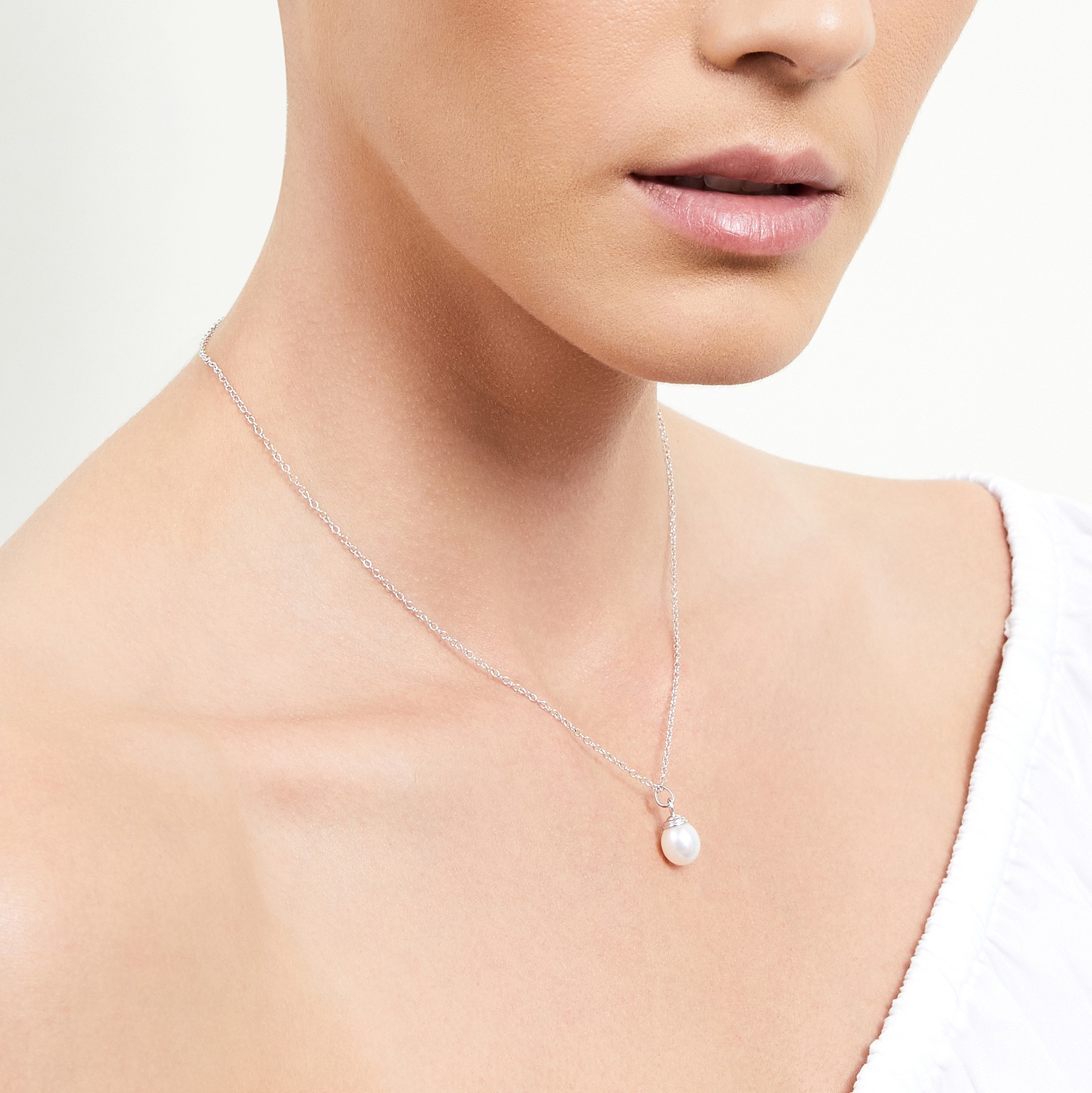 Das Model trägt einen Drop Shape Hope-Anhänger mit 8–9 mm großen Perlen in AAAA-Qualität